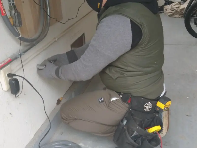 Electrician performing outlet wiring in a Allen garage